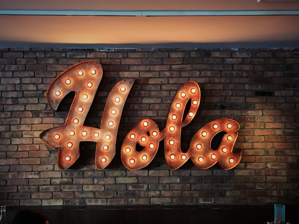 砖墙上的灯上有Hola标志